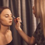 Makijażystka robi makeup młodej kobiecie